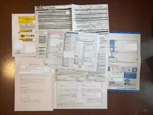 タイトル:Honda認定中古車購入時に記入する書類 内容:Hondaの認定中古車を購入する際に、販売店から届いた複数の書類の画像。
